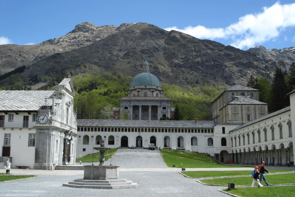 Vista panoramica di Biella con il Sacro Monte sullo sfondo, evidenziando la bellezza del paesaggio e l'architettura storica