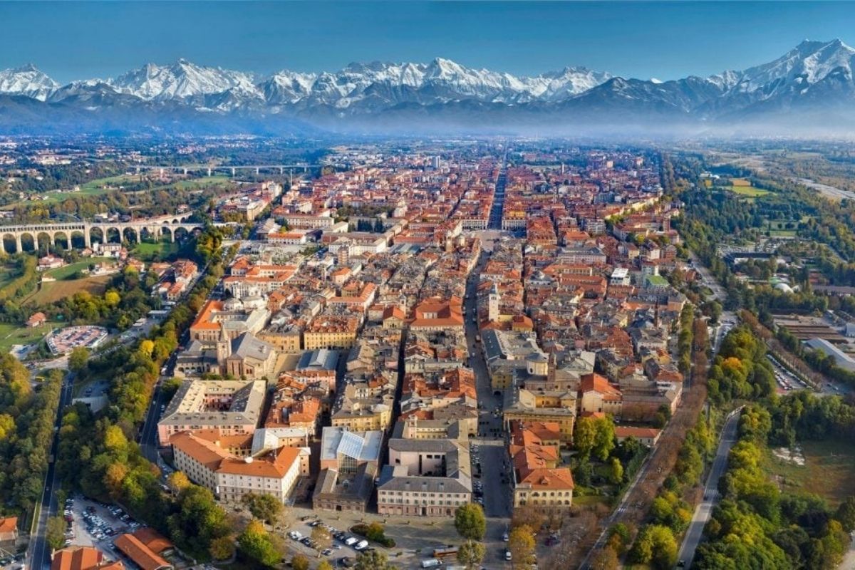 Vista panoramica di Cuneo con le Alpi sullo sfondo e eventi culturali in corso