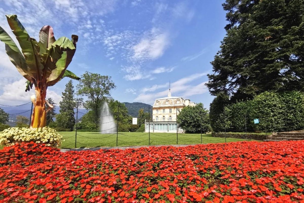 Veduta dei Giardini di Villa Taranto a Verbania, con fiori colorati e il Lago Maggiore sullo sfondo